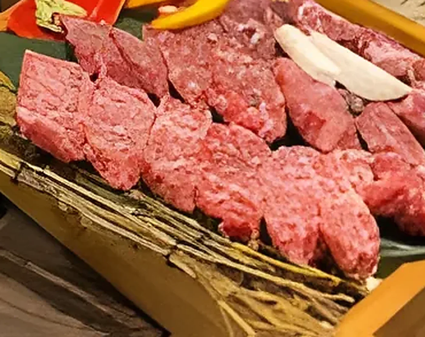 A wooden board of marbled Korean beef ready for the grill